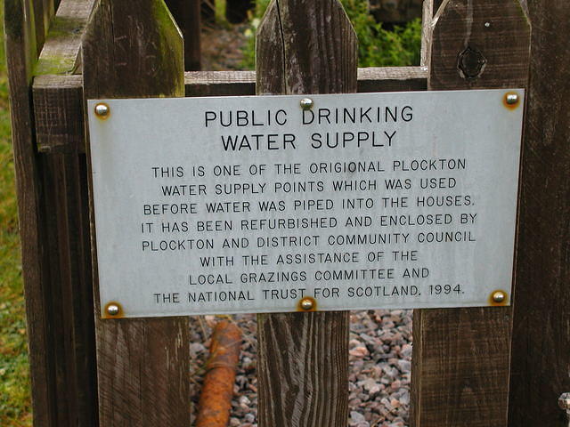 Sign on the old village water pump